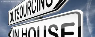 Zwei Straßenschilder zeigen in entgegengesetzte Richtungen: Eines mit der Aufschrift „Outsourcing“, das andere mit „In-House“.