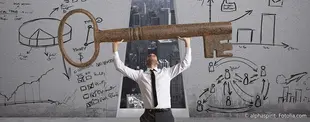 Ein Geschäftsmann hebt einen großen, rostigen Schlüssel in die Luft, umgeben von handgezeichneten Diagrammen, die Strategie, Erfolg und Schlüsselkompetenzen symbolisieren